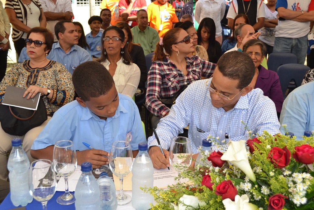 Jose Rafael Vargas firma acuerdo con la escuela Andres Bello con la representación de un niño de la escuela